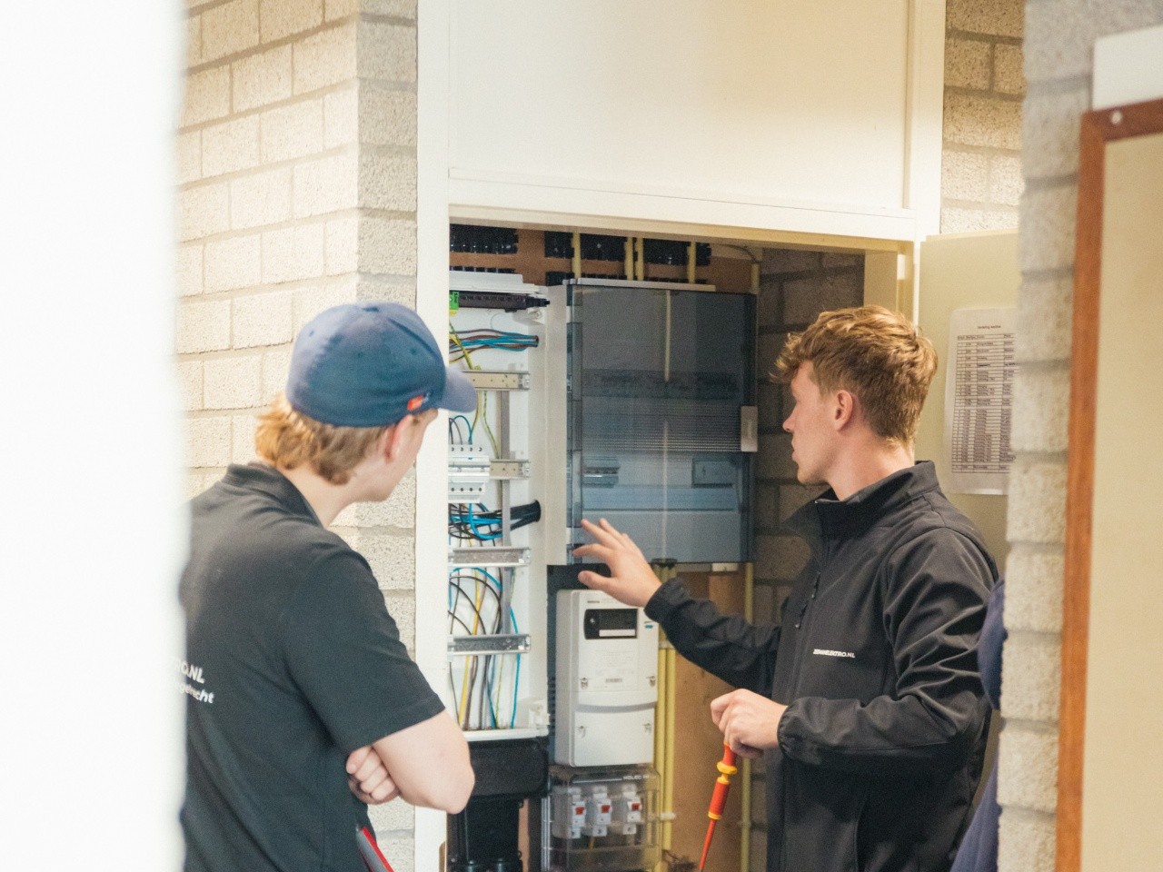 Monteurs van Zeemanelektro in gesprek bij een meterkast