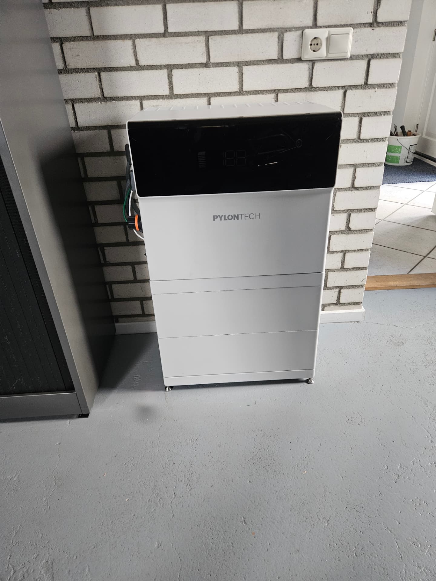 Geïnstalleerde Pylontech 3-fasen thuisbatterij van 10 kW en 10 kWh tegen een binnenmuur in Emmen